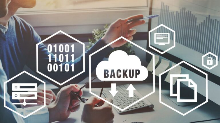 Duas pessoas em um escritório olhando para um monitor. Sobrepostos à cena, hexágonos brancos flutuantes contêm ícones técnicos: um servidor de rack, código binário (01001), uma nuvem com a palavra "BACKUP" e setas de sincronização, um monitor e pastas de arquivos.